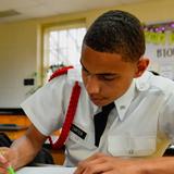 Hargrave Military Academy Photo #12 - A Hargrave cadet in dress whites concentrating on written work at his desk